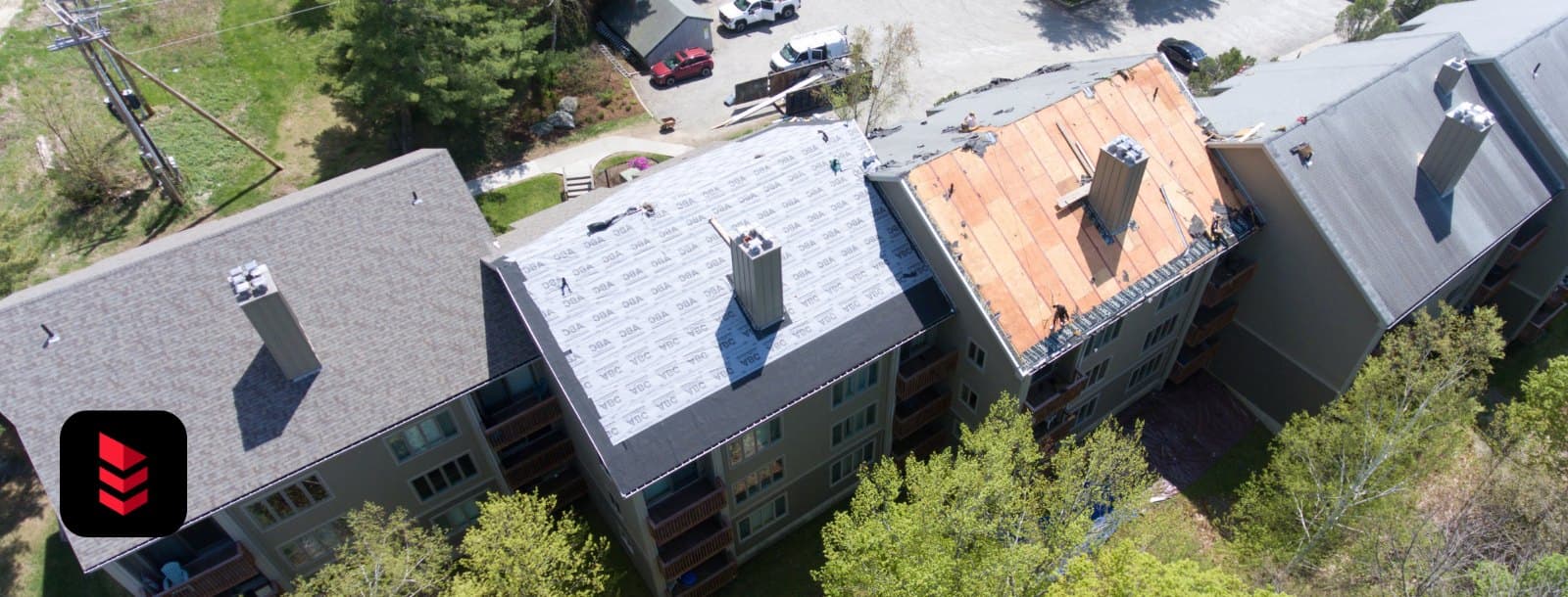 Aerial view of condo buildings partway through a shingle re-roof